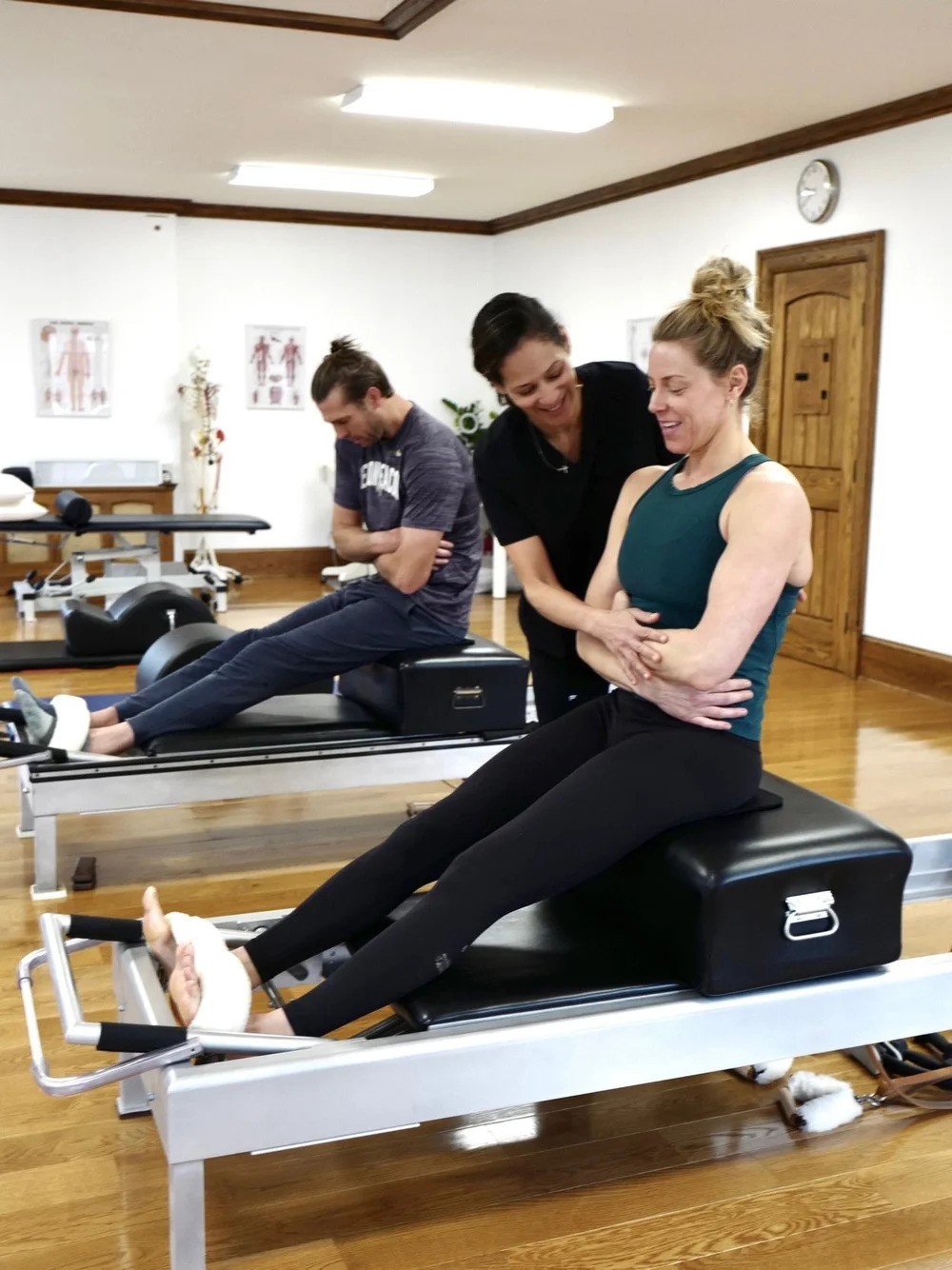 alexandra-pilates-grand-rapids-treating-woman Alexandra, an osteopath and Pilates instructor in Grand Rapids, using classical Pilates to help a female patient.