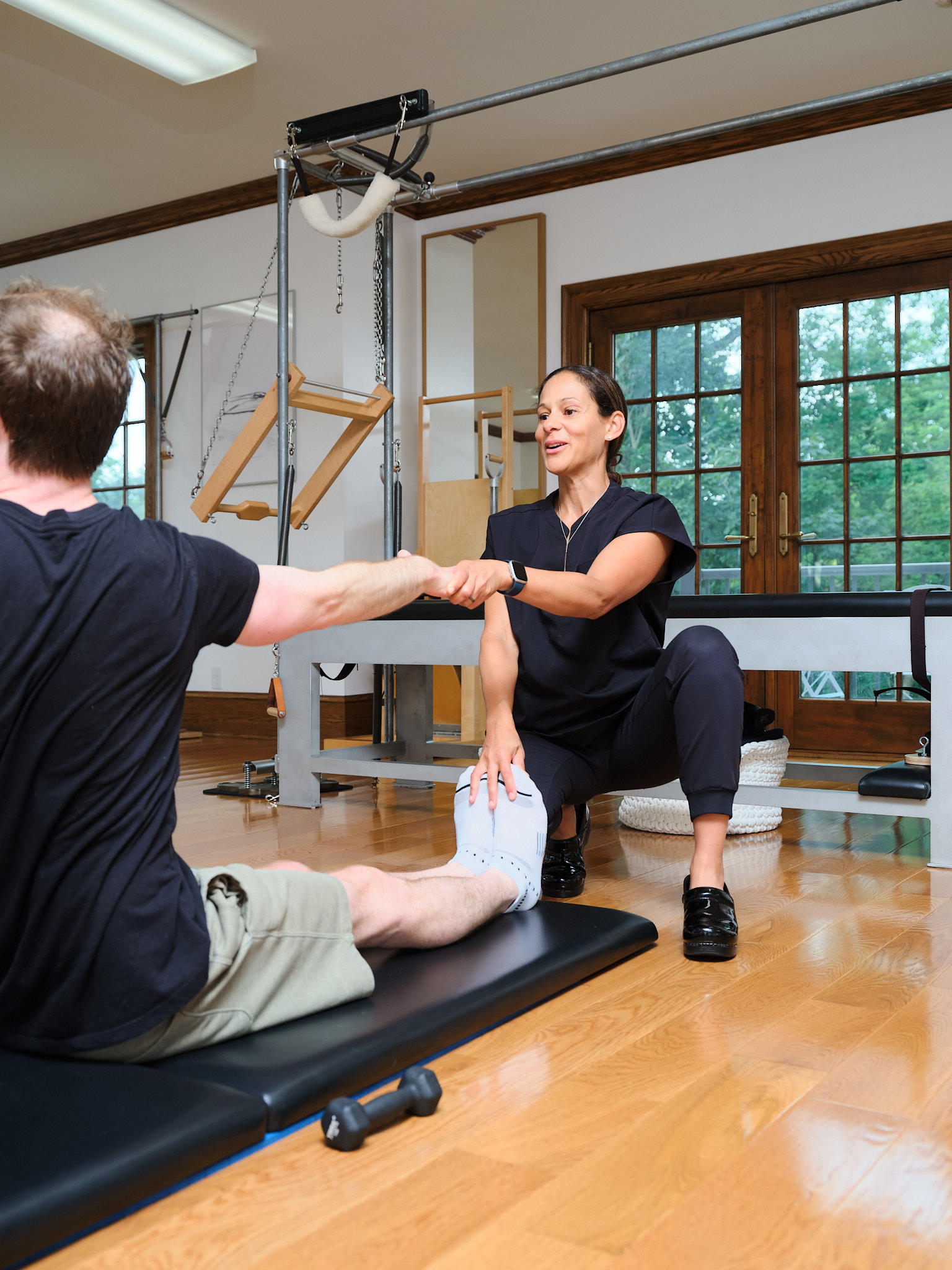 alexandra-pilates-grand-rapids Alexandra, an osteopath and Pilates instructor in Grand Rapids, using classical Pilates to help a patient.