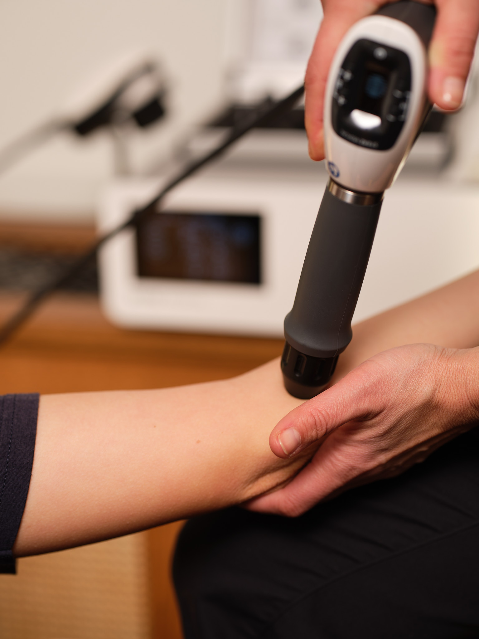 Handheld shockwave applicator treating forearm tissue for chronic tendon pain.