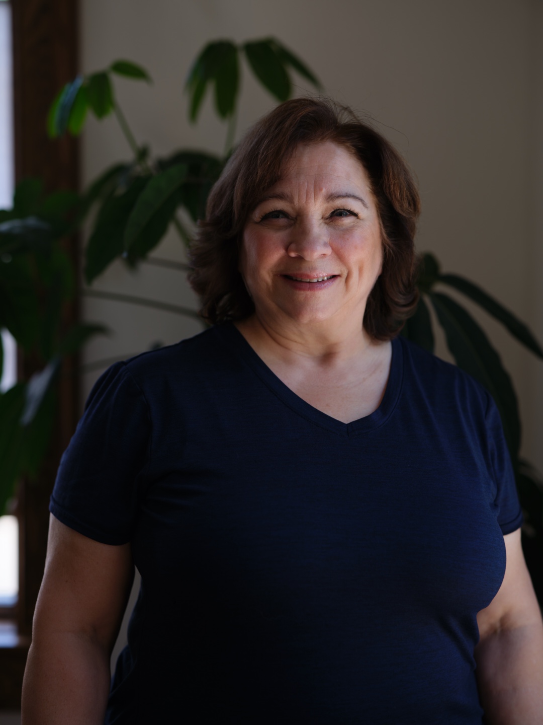 Connie, a certified classical Pilates instructor trained by a second-generation teacher, smiling for her professional headshot.